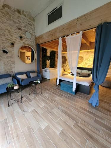 1 dormitorio con 1 cama y 1 sofá en una habitación en Studio de charme - Le Céleste, en Vergèze