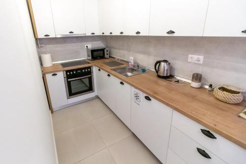 a small kitchen with white cabinets and a sink at Gajeva Rooms - Malmö apartment SELF CHECK-IN in Virovitica