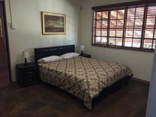 a bedroom with a bed and a window at The Cradle Berry Farm in Muldersdrift