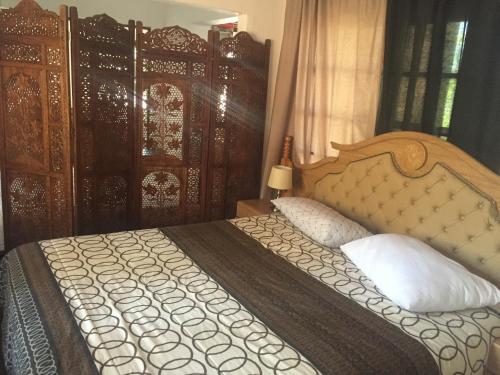 a bedroom with a large bed with a wooden headboard at The Cradle Berry Farm in Muldersdrift