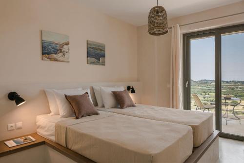 een slaapkamer met een groot bed en een groot raam bij Villa Lavanta - Iris sunset villas in Lépedha