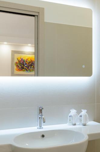a bathroom sink with a mirror and a white sink at Ruffini Rooms in Termoli