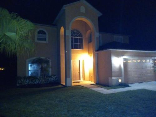 a large house with a garage at night at Amore's luxurious 4 bedroom home. in Kissimmee