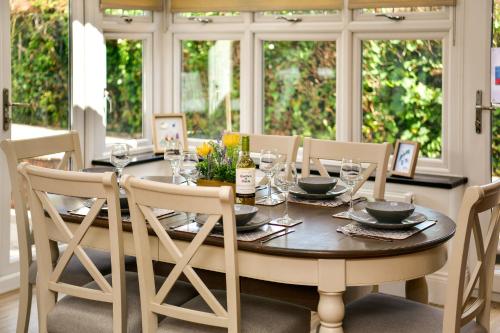 een eetkamer met een houten tafel en stoelen bij Just Stay Wales - Highmead House, Swansea 