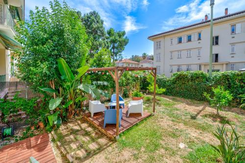 een tuin met een prieel en stoelen bij Charmant appartement proche mer in Nice