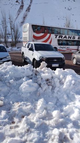 a pile of snow next to a bus and a car at Alojamiento Quincho Pascual in Las Compuertas