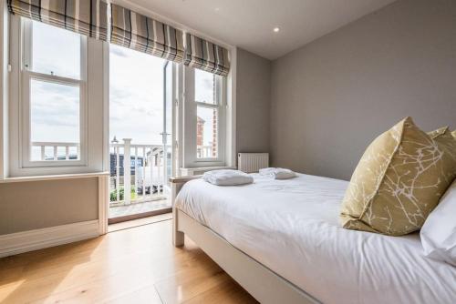 um quarto com uma cama e uma grande janela em Swn-y-Don em Aldeburgh