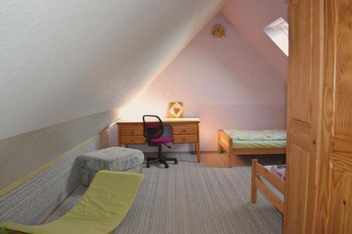 Zimmer im Dachgeschoss mit einem Schreibtisch und einem Stuhl in der Unterkunft Hof Schlossblick in Bösdorf
