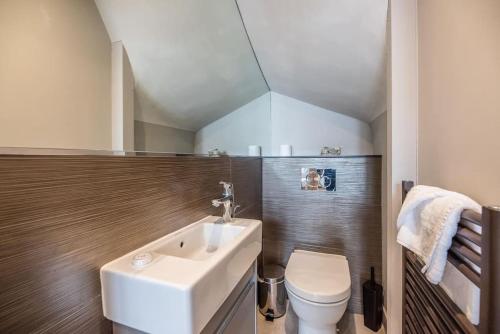 ein Badezimmer mit einem weißen Waschbecken und einer Toilette in der Unterkunft Swn-y-Don, Aldeburgh in Aldeburgh