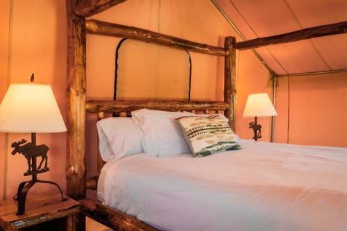 a bedroom with a wooden bed with two lamps at Teton Peaks Resort in Tetonia