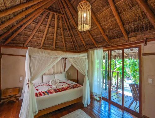 a bedroom with a bed with a chandelier at Xhule Hotel Boutique in Tulum
