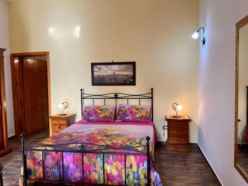 a bedroom with a bed with a colorful comforter at Masseria Agriturismo Fontanella in Nardò