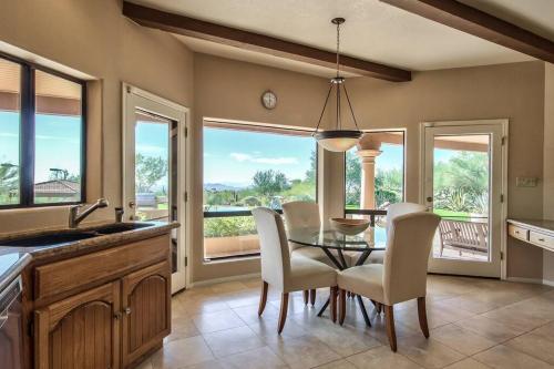 a dining room with a table and chairs and windows at Private Luxury Estate on 5 acres in Scottsdale