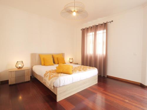 a bedroom with a bed with yellow pillows on it at Forte do Ilhéu de Vila Franca in Vila Franca do Campo