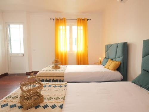 a bedroom with two beds and a basket on the floor at Forte do Ilhéu de Vila Franca in Vila Franca do Campo