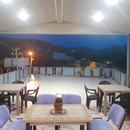 a patio with tables and chairs on a roof at Belas House With Terrace in Kutaisi