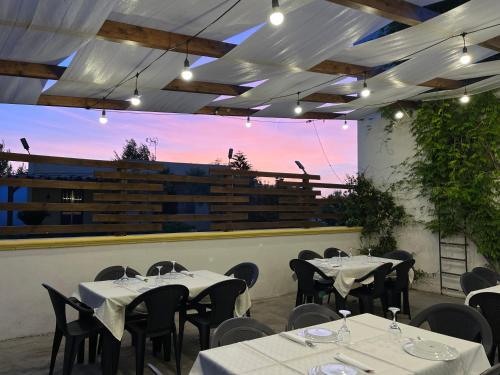 a restaurant with white tables and chairs with the sunset at Masseria Agriturismo Fontanella in Nardò