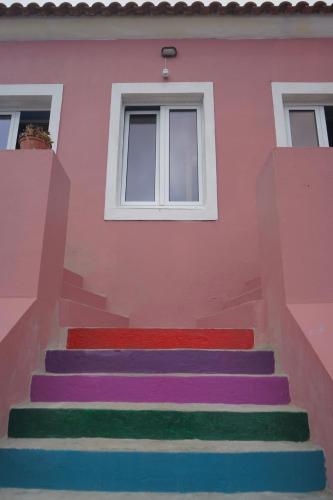 a pink house with colorful stairs in front of it at The Pink House in Faja Grande