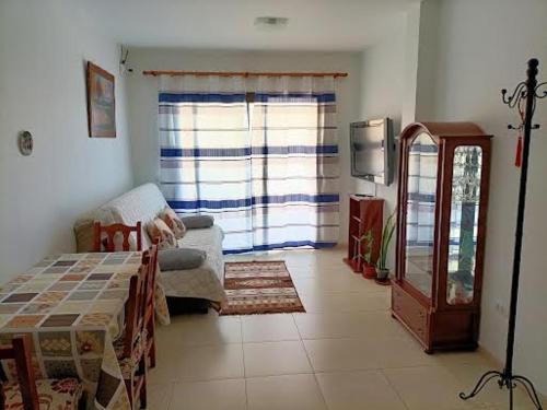 ein Wohnzimmer mit Sofa und Fenster in der Unterkunft Vivienda vistas bonitas in Calera