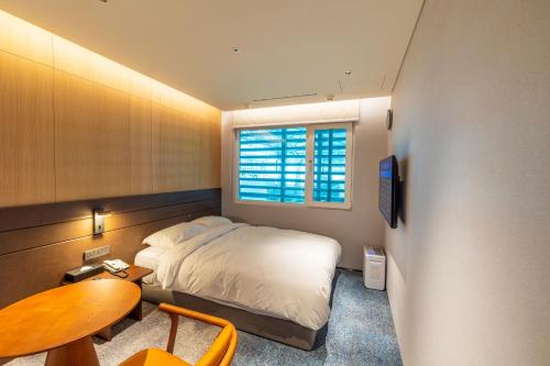 仁川にあるインチョン エアポート トランジット ホテル ターミナル 1のベッドルーム1室(ベッド1台、テーブル、窓付)