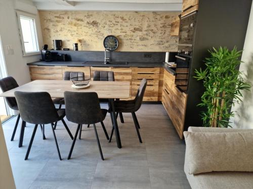 una sala da pranzo con tavolo e sedie in legno di la maison de léo a Les Sables-dʼOlonne