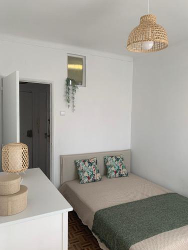 a white room with a bed and a table at Apt 20 min from downtown train in Amadora
