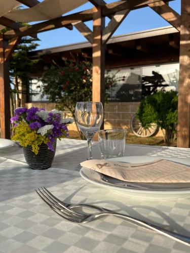 a table with plates and glasses and flowers on it at Masseria Agriturismo Fontanella in Nardò