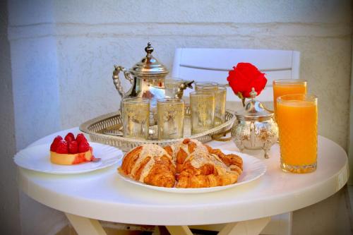 a table with a breakfast of croissants and orange juice at Apartment Borj Rayhane in Tangier