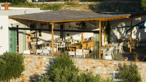 a patio with tables and chairs on a building at Anassa Cycladic Village in Galissas