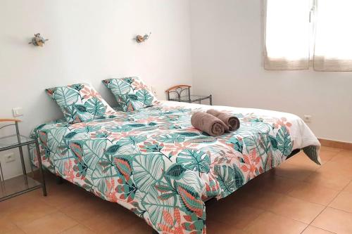 łóżko z kolorową kołdrą i poduszkami w obiekcie VILLA GRATIAN w mieście Saint-Hilaire-de-Brethmas