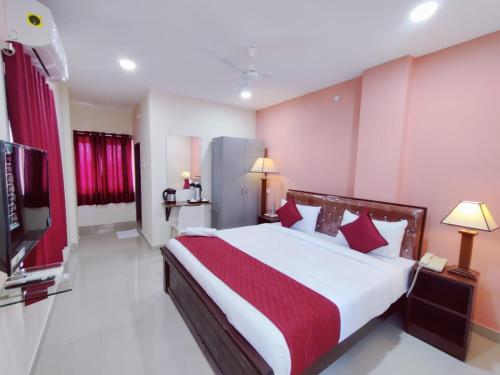 una camera con un grande letto e una televisione di Hotel Prime Classic a Shamshabad