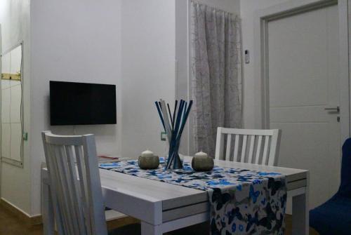 stół jadalny z 2 krzesłami i telewizor w obiekcie DaLi House w Pizie