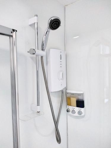 a shower with a shower head in a bathroom at Ashley Holiday Home, Close To City Centre With Free Parking in Dalneigh