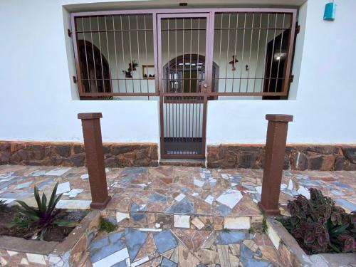 - l'entrée d'un bâtiment avec un portail et une terrasse en pierre dans l'établissement Casa Estação da Paz, à Miguel Pereira