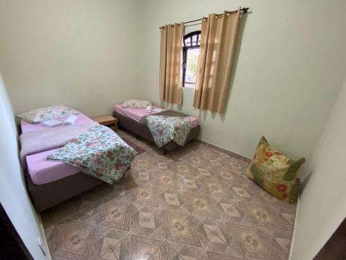 Cette chambre comprend 2 lits jumeaux et une fenêtre. dans l'établissement Casa Estação da Paz, à Miguel Pereira
