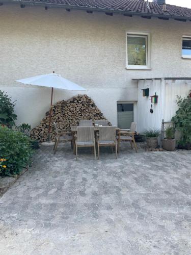 a patio with a table and an umbrella at Luises Ferienglück in Vernawahlshausen