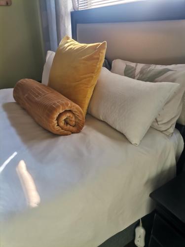 uma cama com várias almofadas em cima em Delightful Home em Pretoria