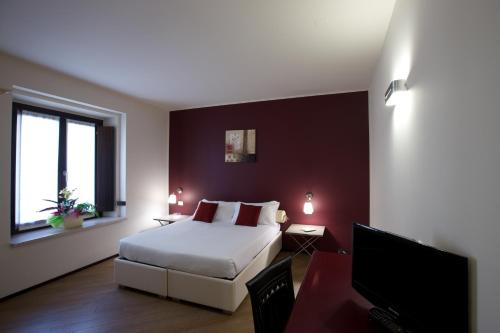 a bedroom with a bed and a flat screen tv at Hotel Leon D'Oro in Mantova