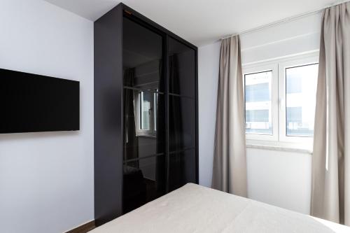 a bedroom with a black cabinet with a television at Apartment Koc, Okrug Gornji - with a pool in Trogir