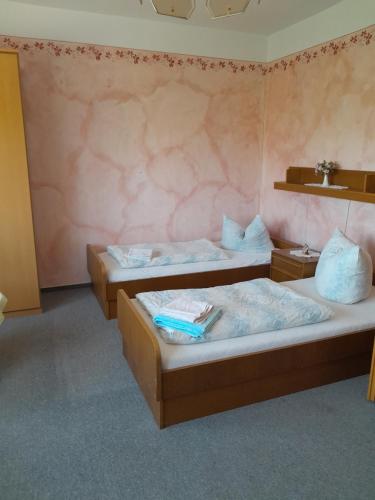 two beds in a room with pink walls at Sport & Freizeit Centrum Pension in Heudeber