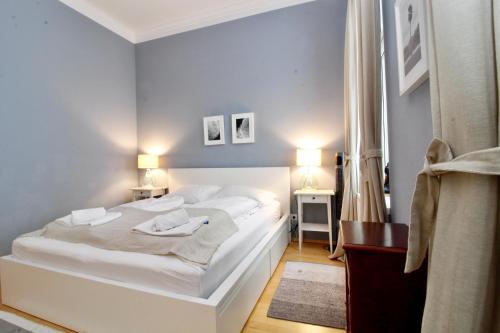 a bedroom with a large white bed and two tables at Classy Apartment in the Heart of Vienna in Vienna