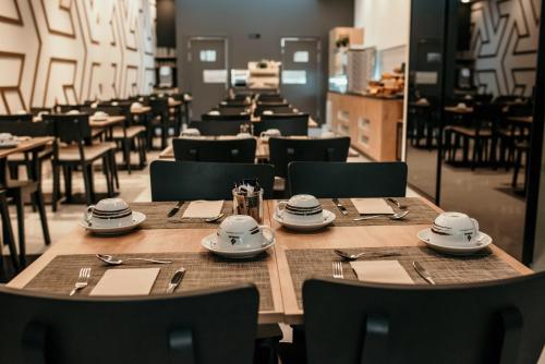 ein Esszimmer mit Holztischen und -stühlen in der Unterkunft Hotel Lux Melide in Melide