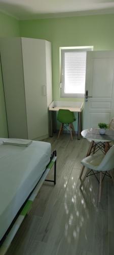 a bedroom with a bed and a table and chairs at Cinema House Single & Double Rooms & Studio Apartments in Pula