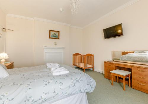 a bedroom with a bed and a dresser with a television at Tracy - Upcott House in Barnstaple
