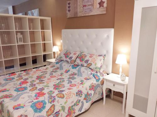ein Schlafzimmer mit einem großen Bett und zwei Nachttischen in der Unterkunft Apartamento TRISTANA in Vecindario