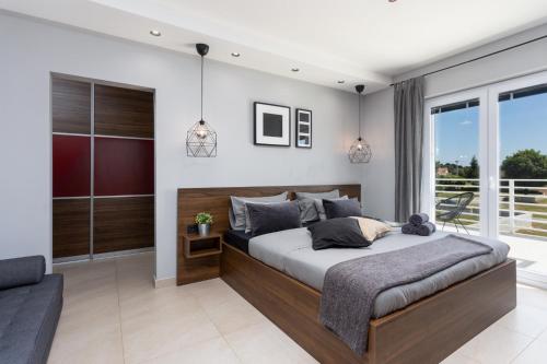 een slaapkamer met een groot bed en een balkon bij Villa Ovis in Peresiji