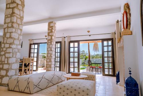 um quarto com uma cama e acesso a um pátio em villa Floratus em Essaouira