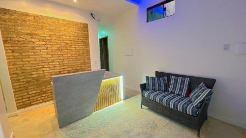 uma sala de estar com um sofá e uma parede de tijolos em Sunsand Beach Suítes e Hostel em Camocim