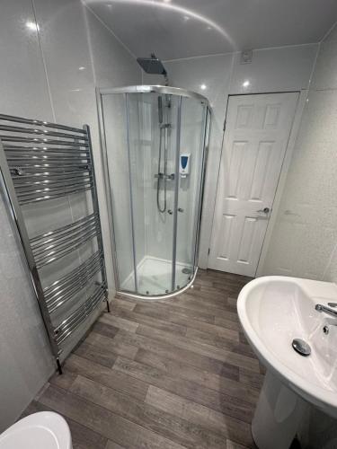 a bathroom with a shower and a toilet and a sink at The Island & Fairfield in Douglas