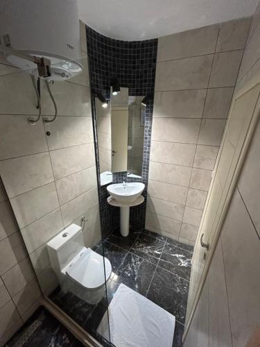 La petite salle de bains est pourvue de toilettes et d'un lavabo. dans l'établissement White Pearl Apartments, à Bar